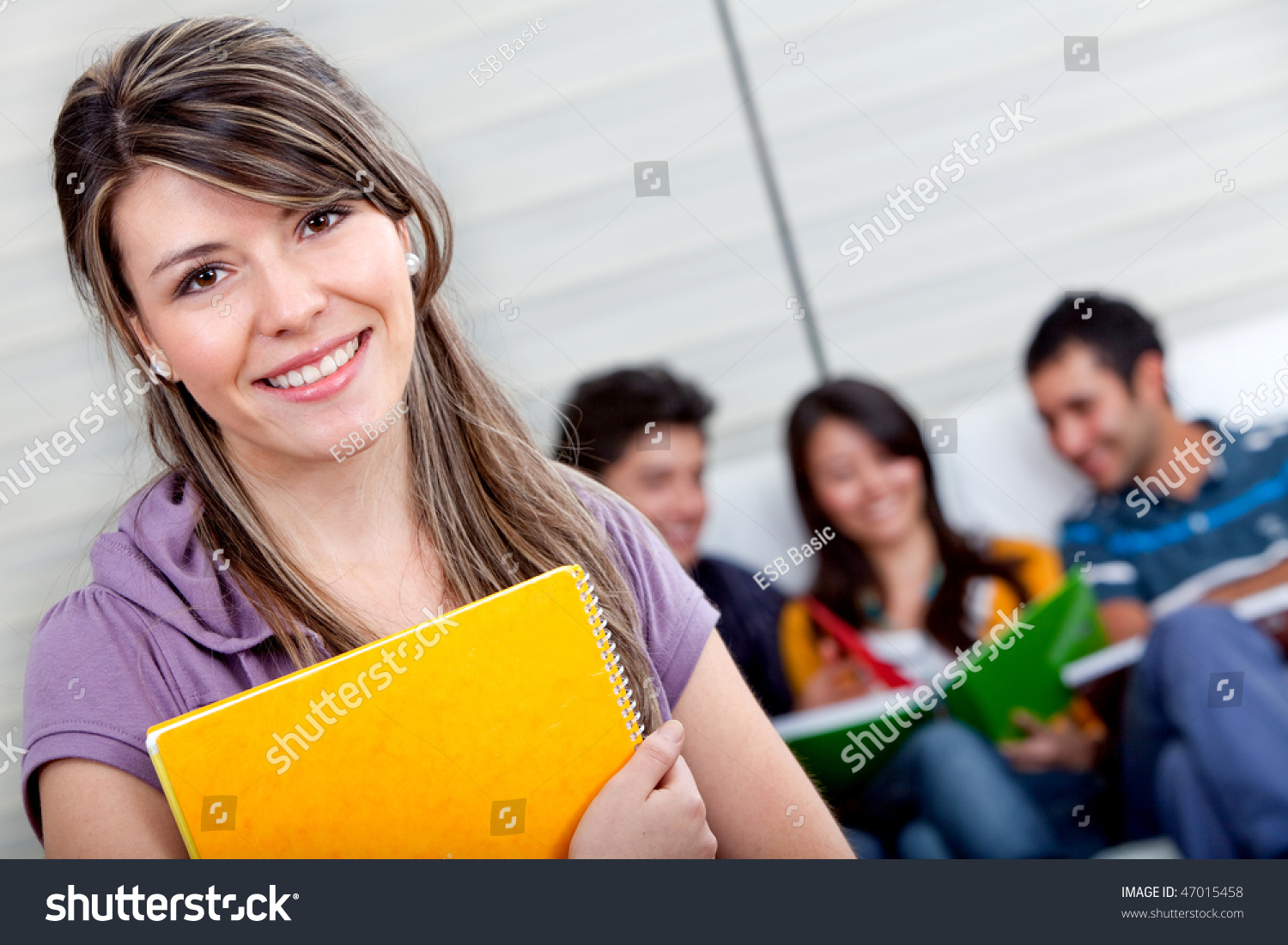 Female student with a group behind isolated over a white background #47015458