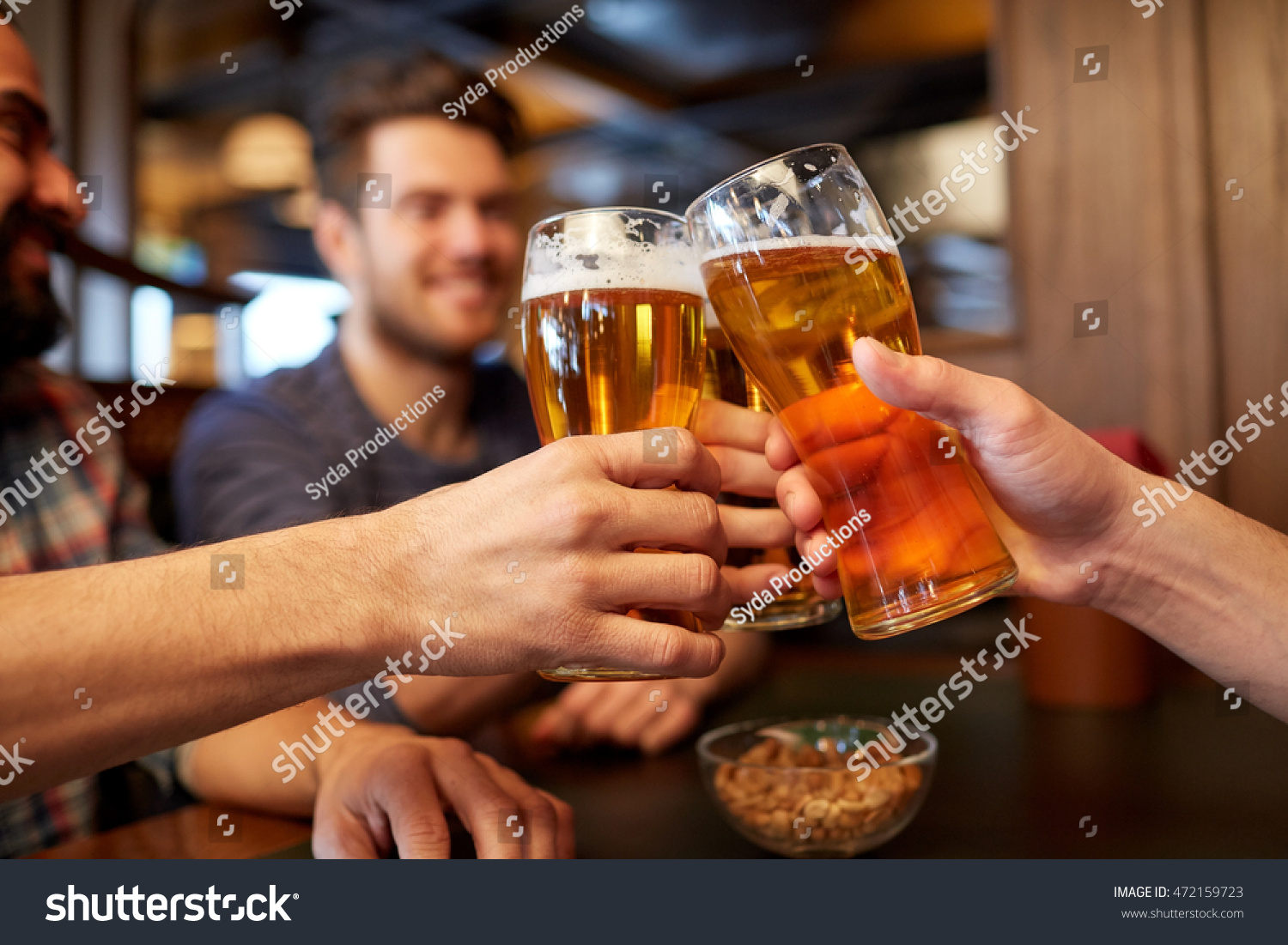 people, men, leisure, friendship and celebration concept - happy male friends drinking beer and clinking glasses at bar or pub #472159723