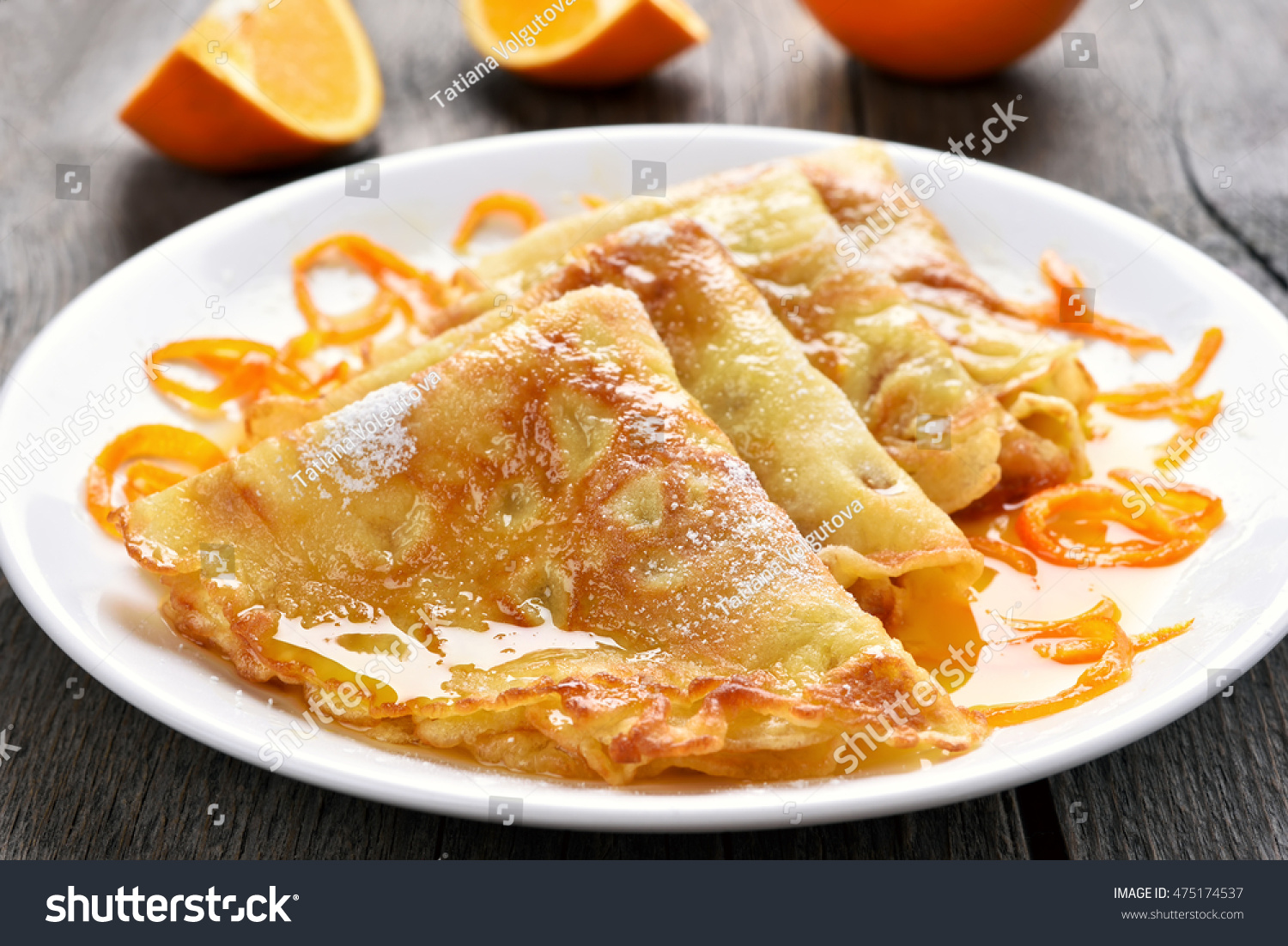Delicious crepes suzette with orange syrup on plate. #475174537