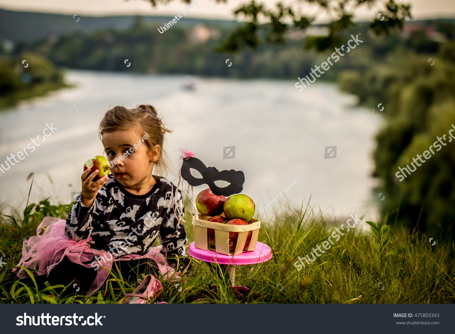 little girl playing on the grass in the daytime, the emotions of a child, a beautiful natural backdrop, playing with a mask #475803343