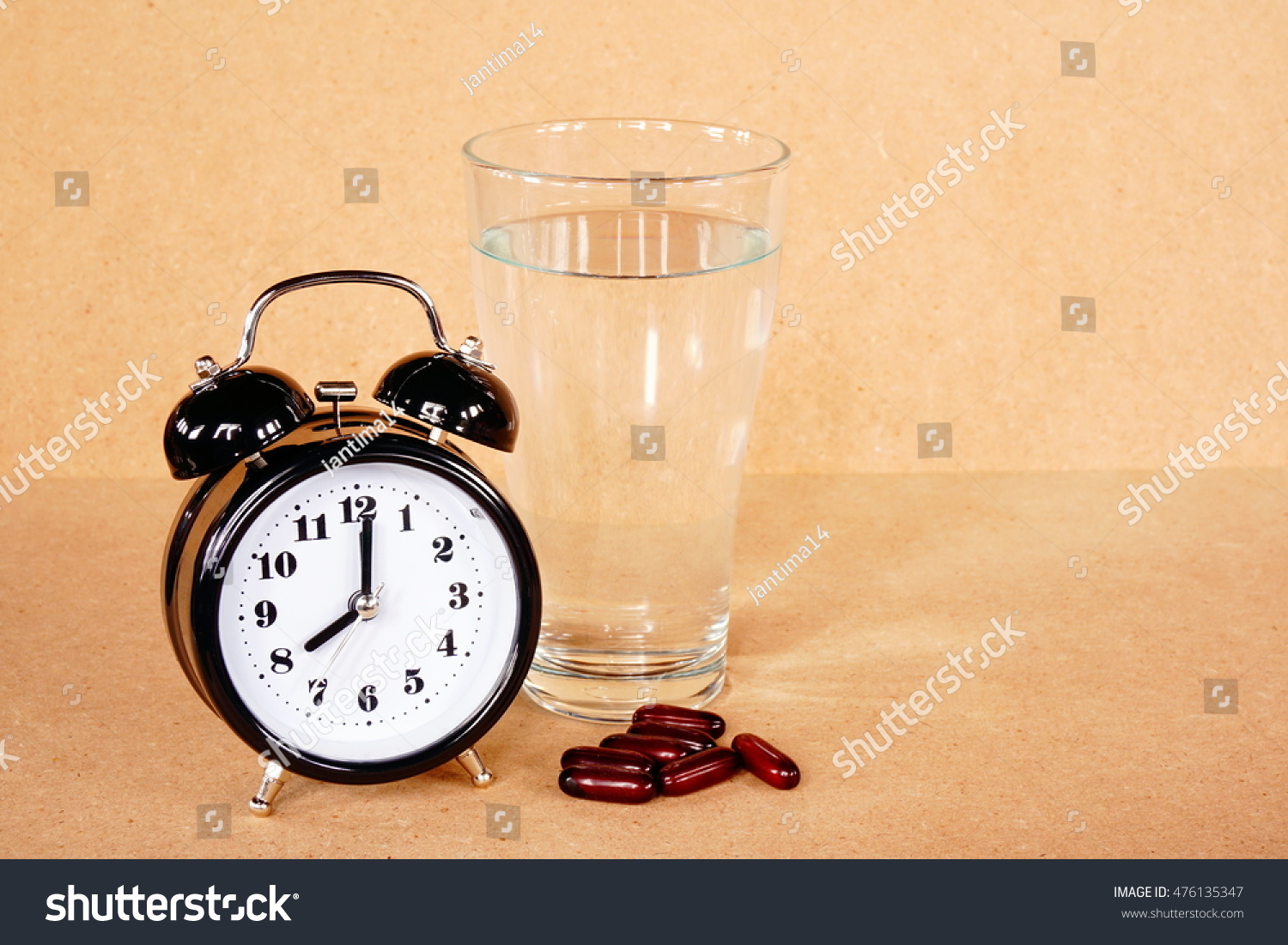Medical  pill and water with alarm clock on wood table in the time for healthy #476135347
