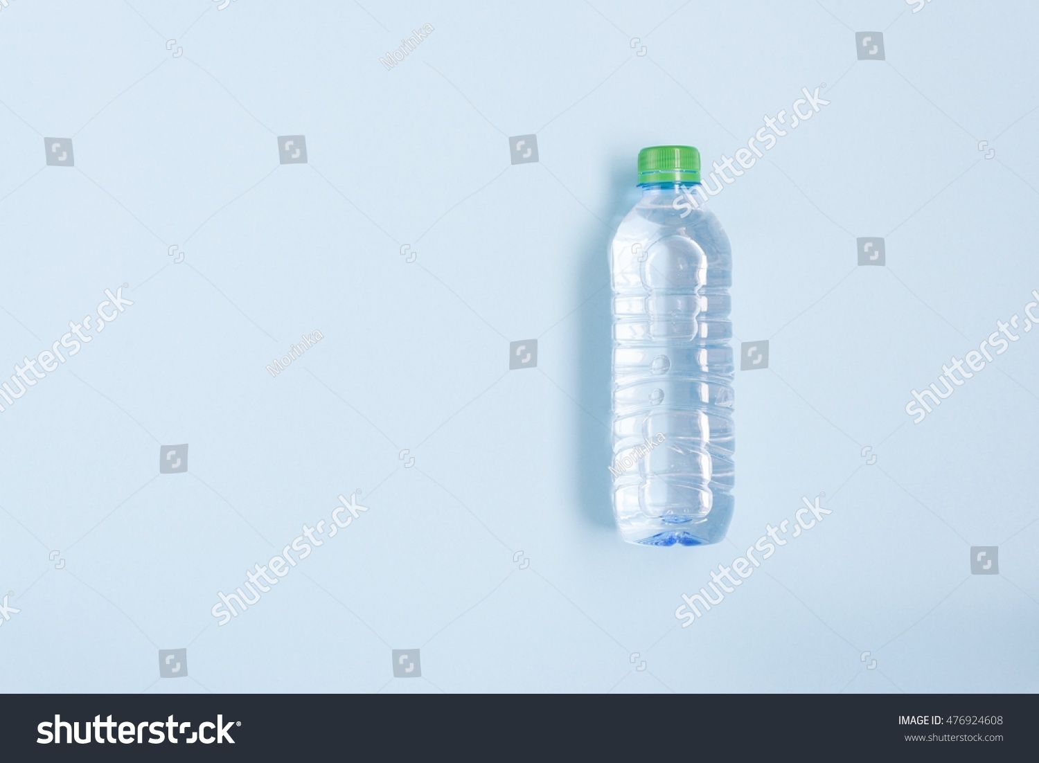 Bottle with clean water over blue background, top view #476924608