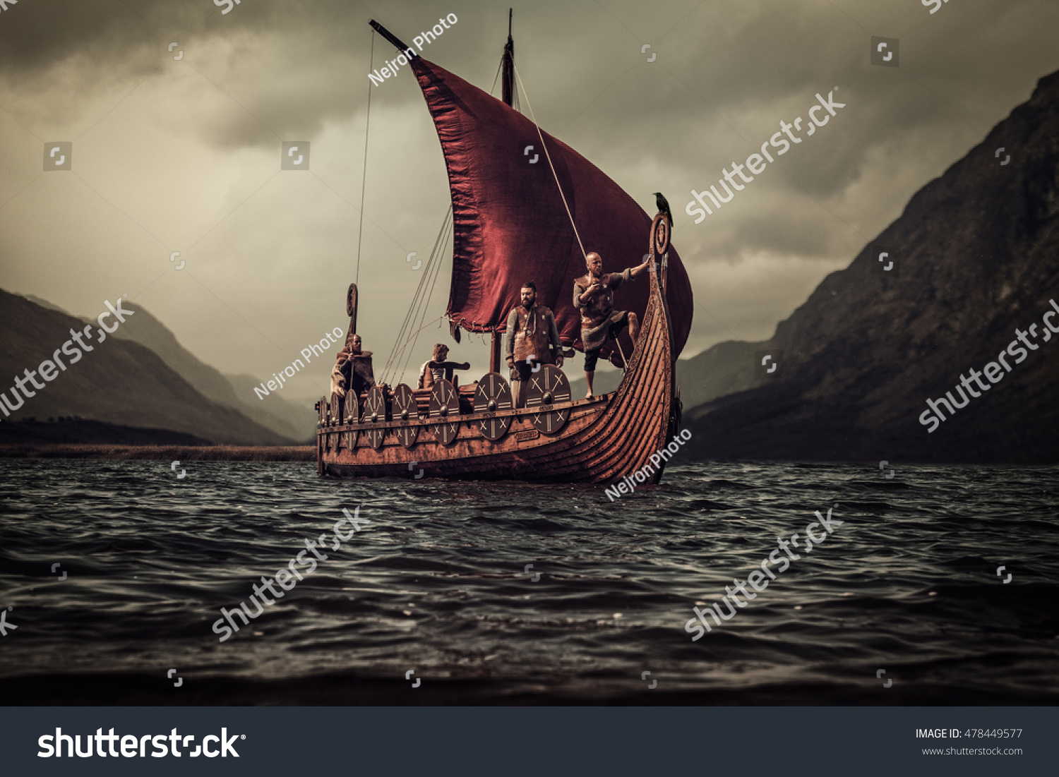 Group of vikings are floating on the sea on Drakkar with mountains on the background. #478449577