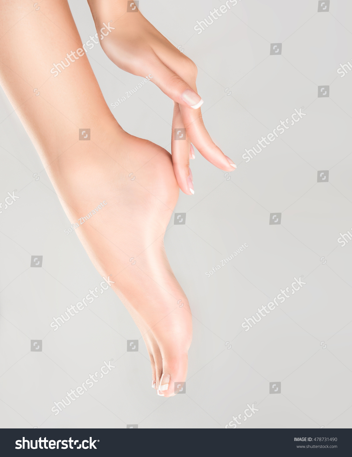 Perfect clean female feet . Beautiful and elegant groomed girl's hand touching  her foot . Spa ,scrub and foot care . #478731490