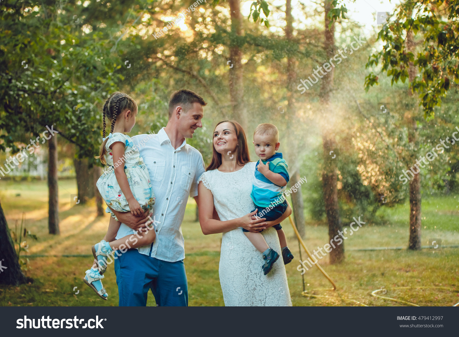 Happy young family of four people walking and having fun in the park #479412997