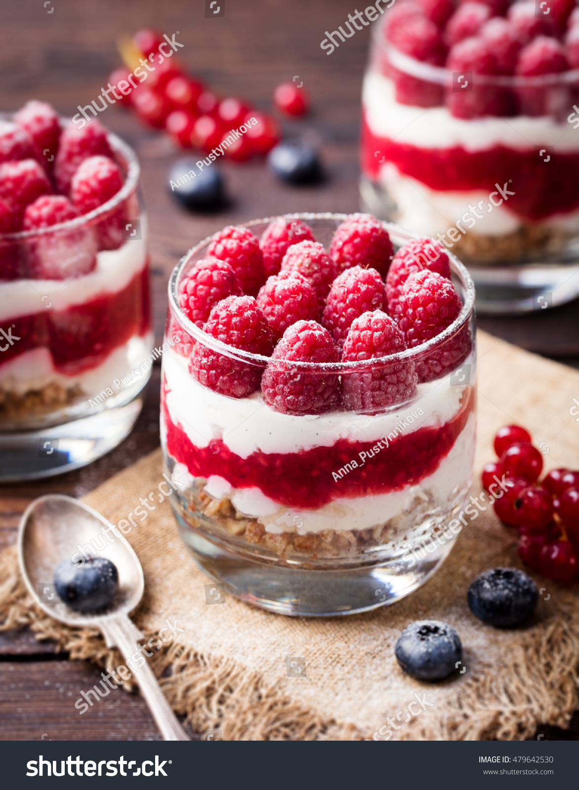 Raspberry dessert, cheesecake, trifle, mouse in a glass on a wooden background #479642530