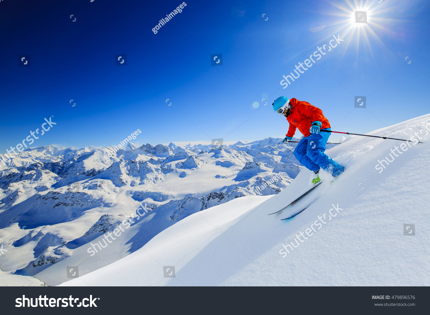 Skier skiing downhill in high mountains in fresh powder snow. Snow mountain range in background. Mt Fort Peak Alps region Switzerland. #479896576