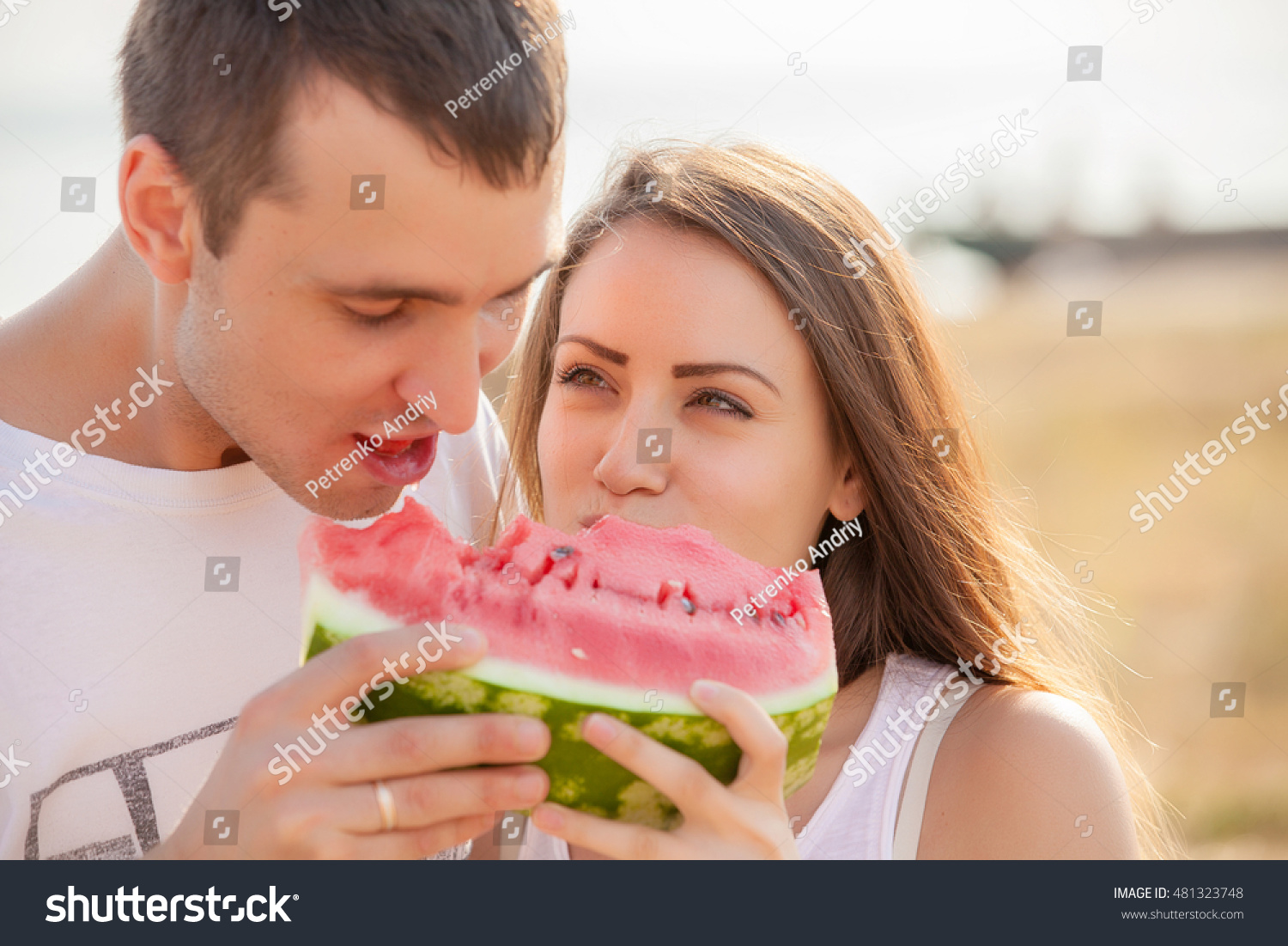 smiling young couple eating fresh melon together #481323748