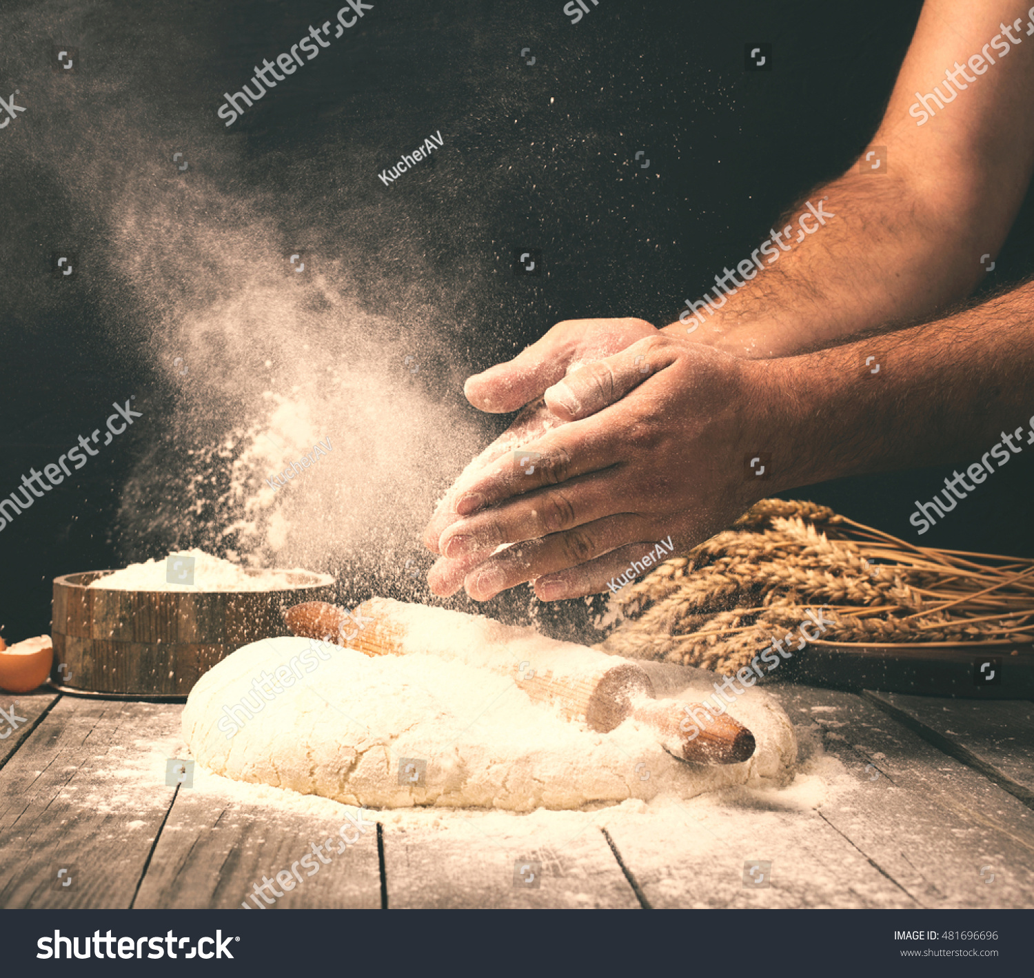 Man preparing bread dough on wooden table in a bakery close up #481696696