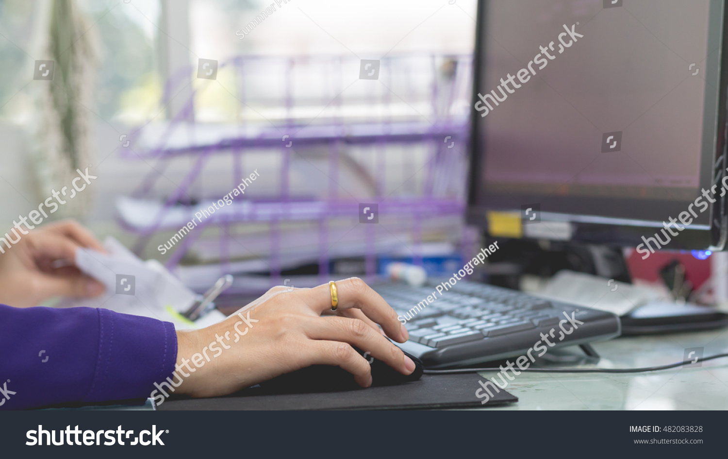 Woman's hand holding a mouse for office work #482083828