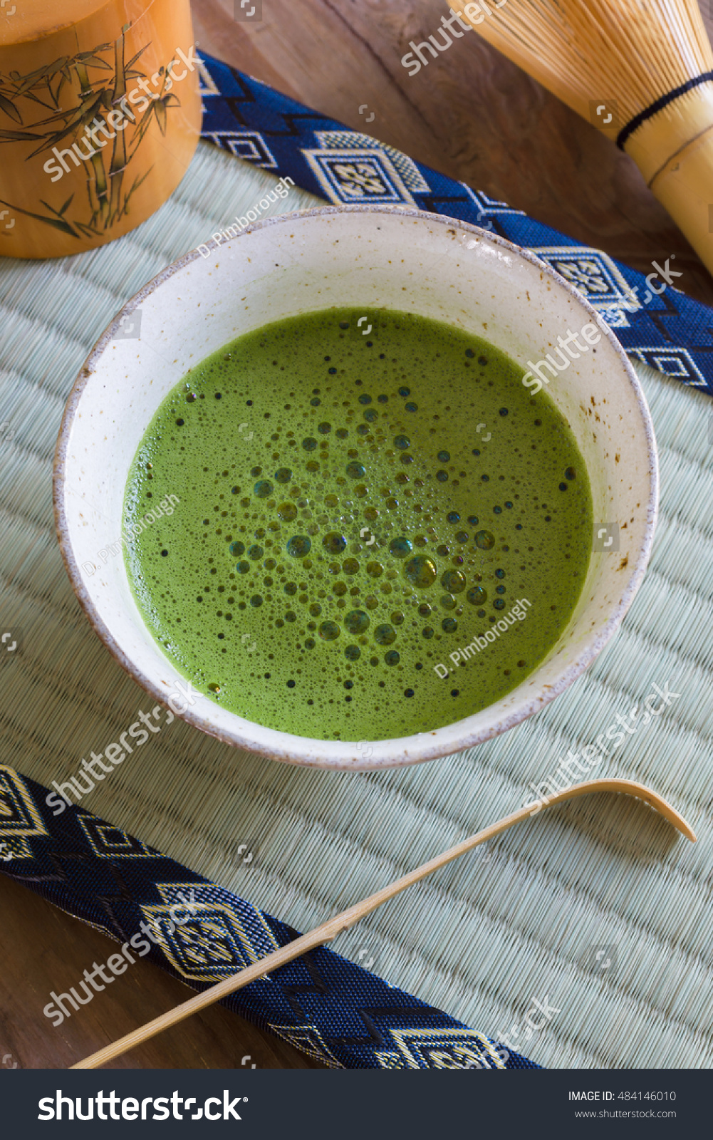 Japanese Matcha green tea in a chawan or traditional ceramic bowl with a tatami mat background #484146010