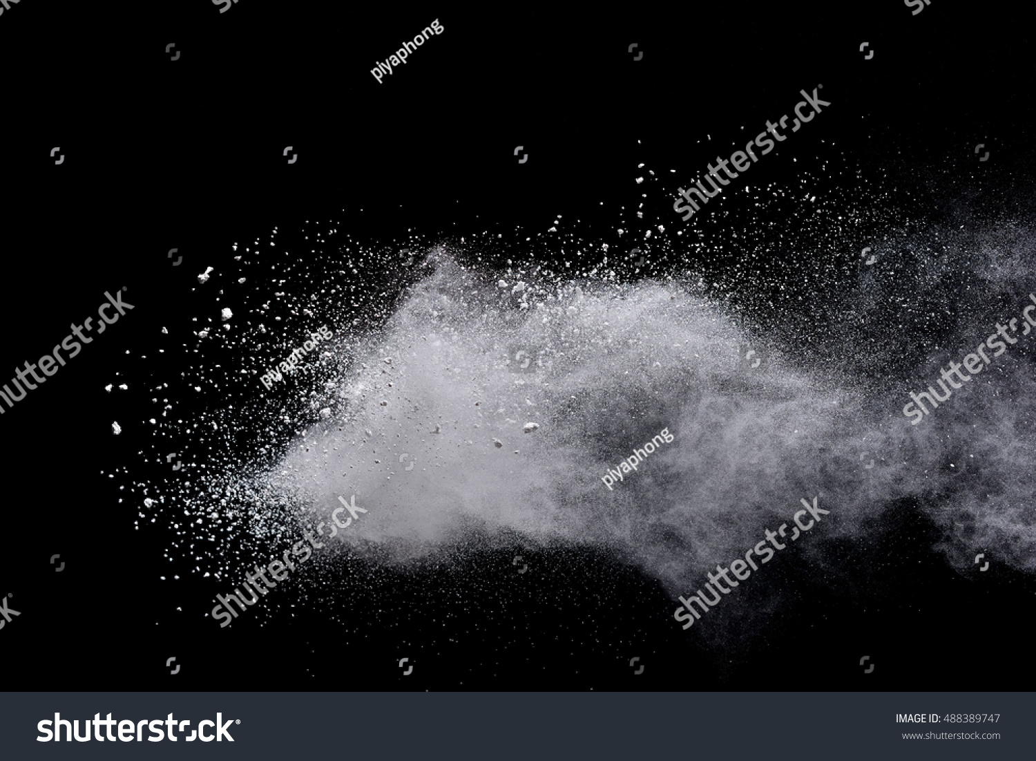 White powder/particles fly after being exploded against black background #488389747