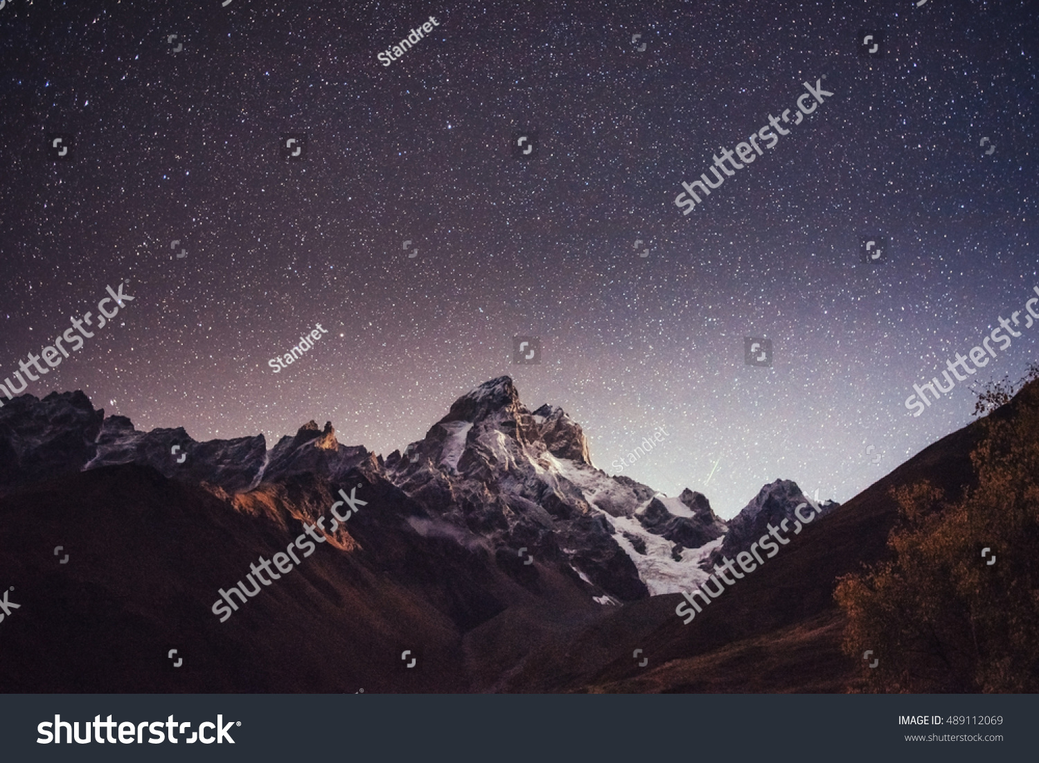 Fantastic starry sky. Autumn landscape and snow-capped peaks. Main Caucasian Ridge. Mountain View from Mount Ushba Meyer, Georgia. Europe. #489112069
