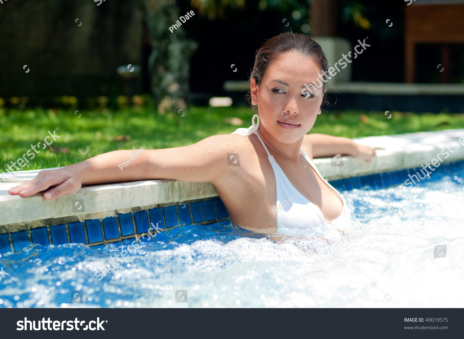 An attractive woman relaxing in the pool #49019575