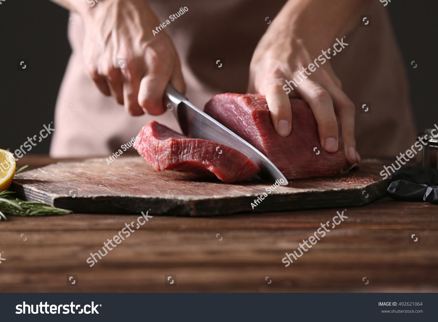 Butcher cutting pork meat on kitchen #492621064