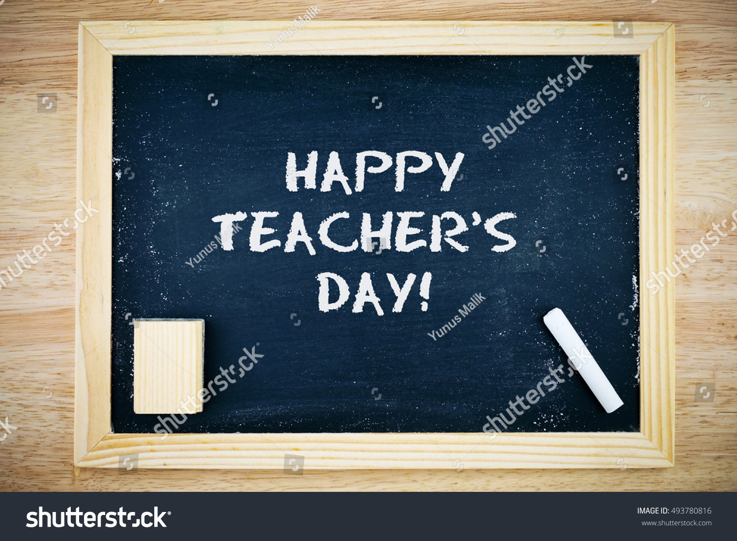 Happy Teacher's Day.. Blackboard with Happy Teacher's Day sign, white chalk and duster on wooden background #493780816