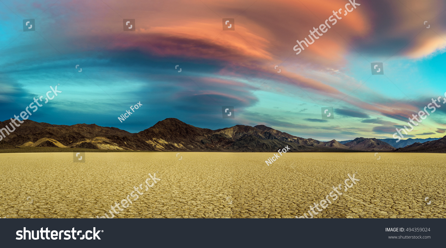 Scenic sunset at Racetrack Playa  in Death Valley National Park. The Racetrack Playa is a scenic dry lake with moving stones that inscribe linear imprints. Long exposure. #494359024