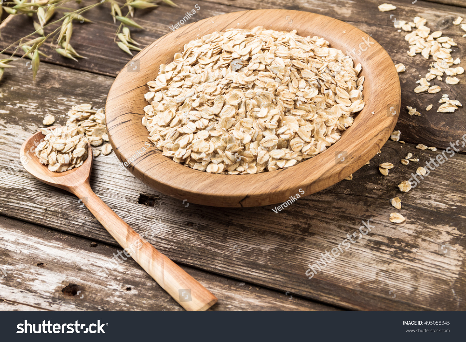 Organic oat flakes on a wooden plate. #495058345