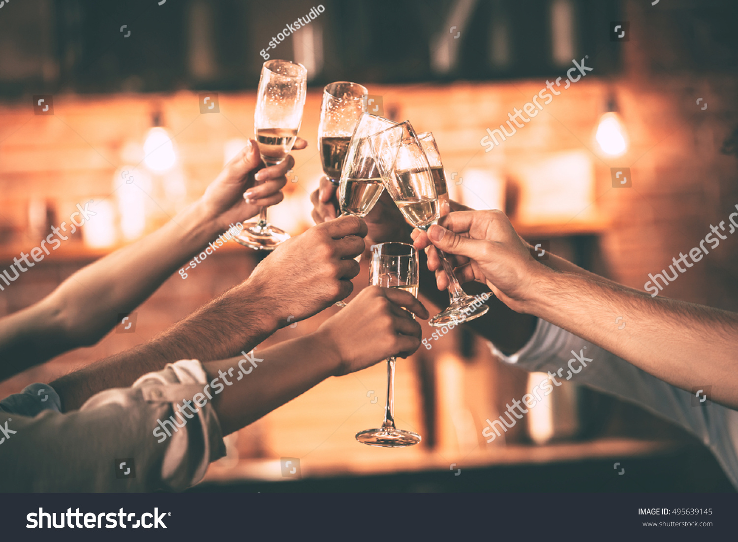 Cheers! Group of people cheering with champagne flutes with home interior in the background #495639145