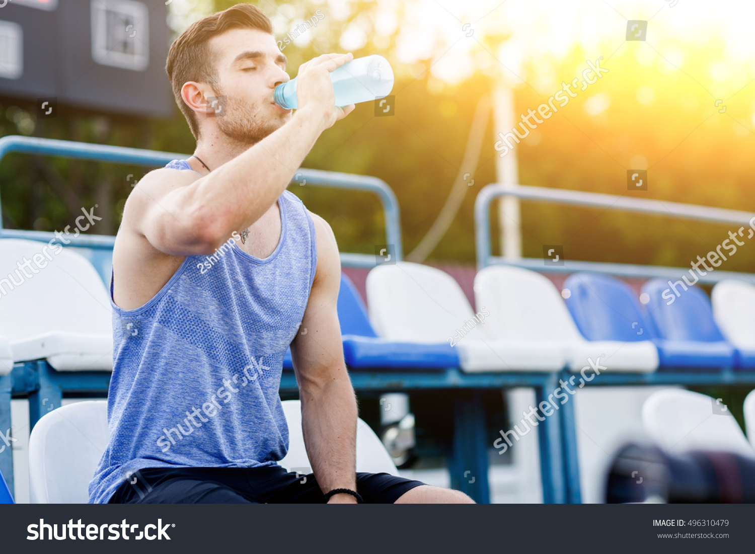 Caucasian man drinking water with his eyes closed after exercises #496310479