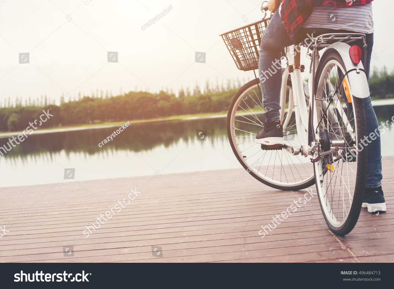 Close-up of young hipster woman holding her foot on bicycle pedal. #496484713