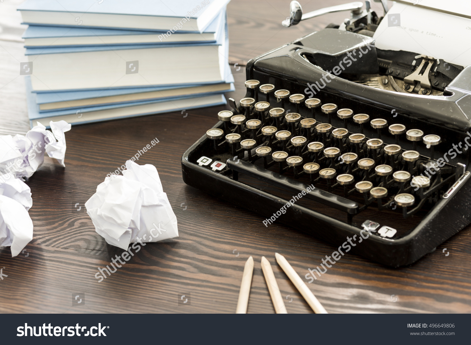 Novelist's desk with the typewriter, books, pencils and creased papers on #496649806