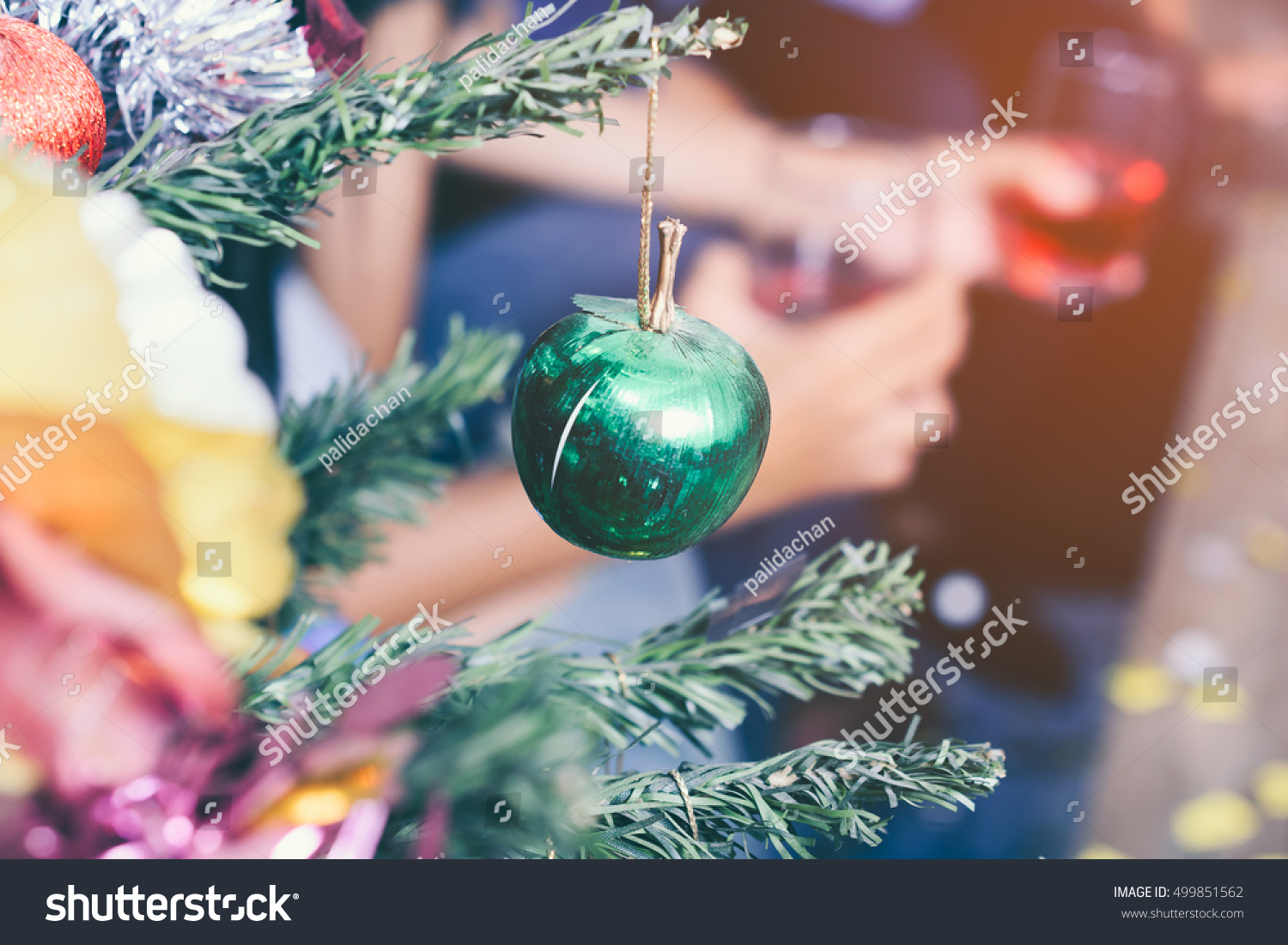 Christmas tree and Christmas decorations with hand holding the glass of red wine background
 #499851562