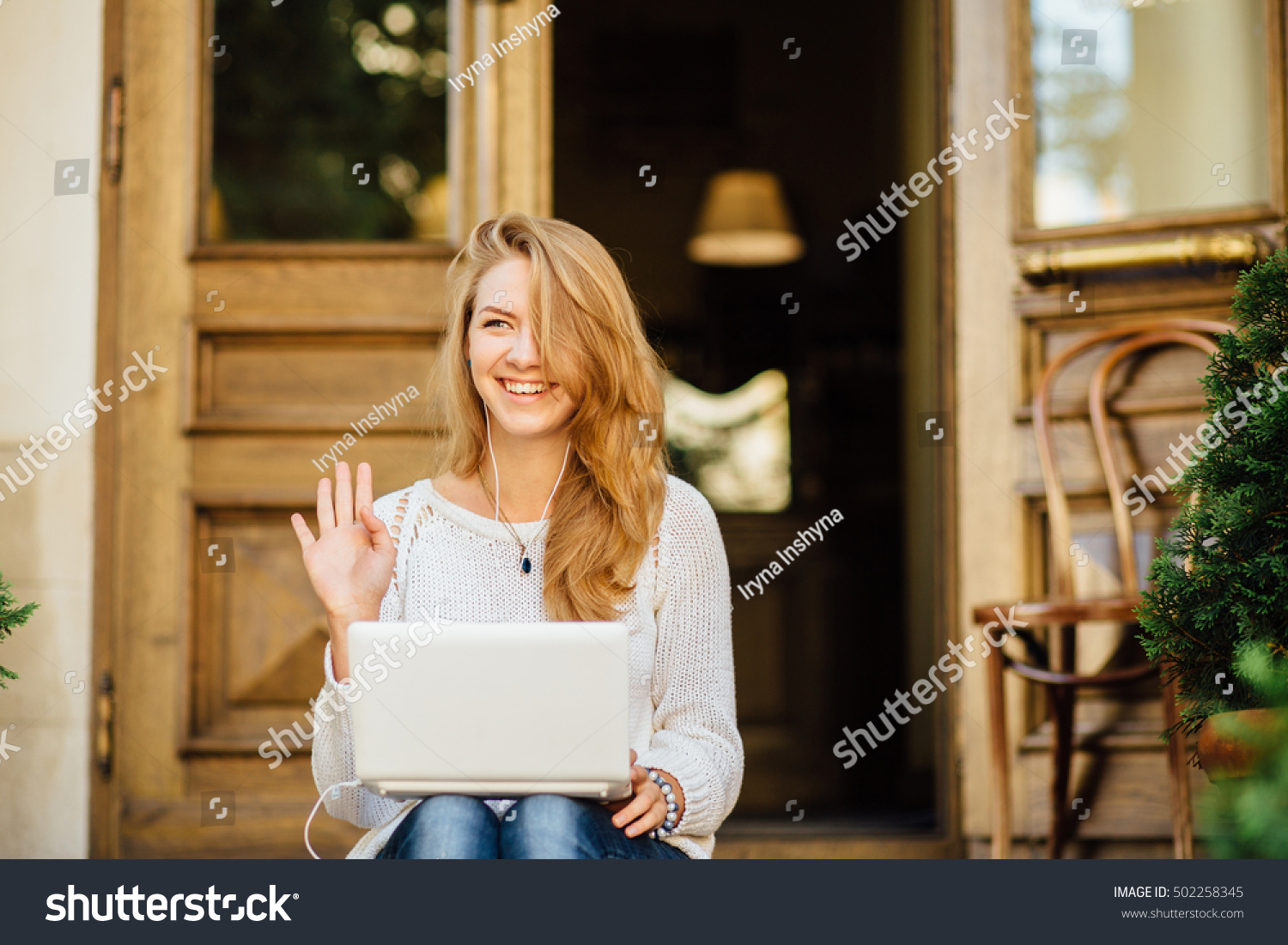 Portrait of a young woman smiling and saying hello in sunny morning #502258345