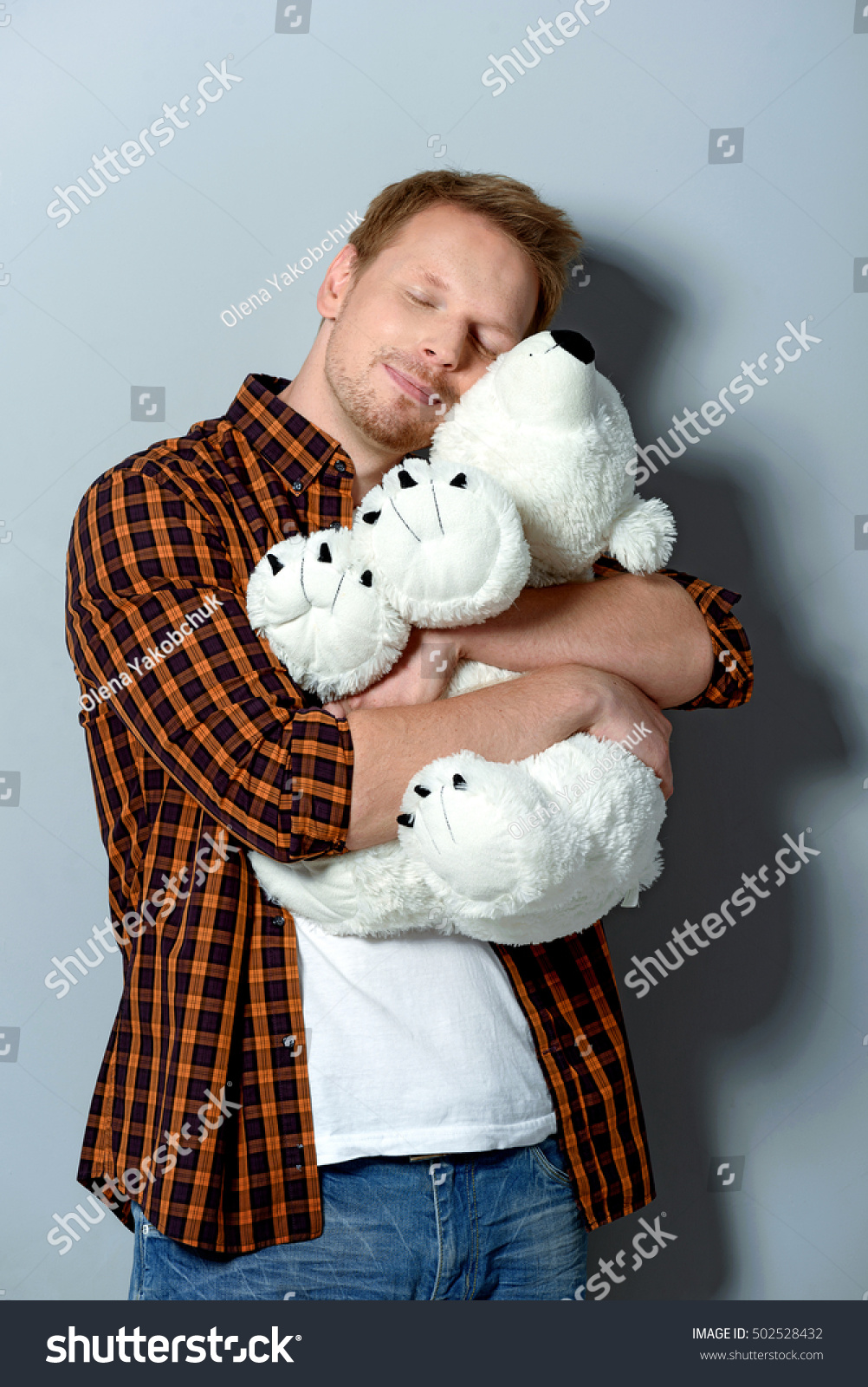 white and soft teddy bear in arms of a man #502528432