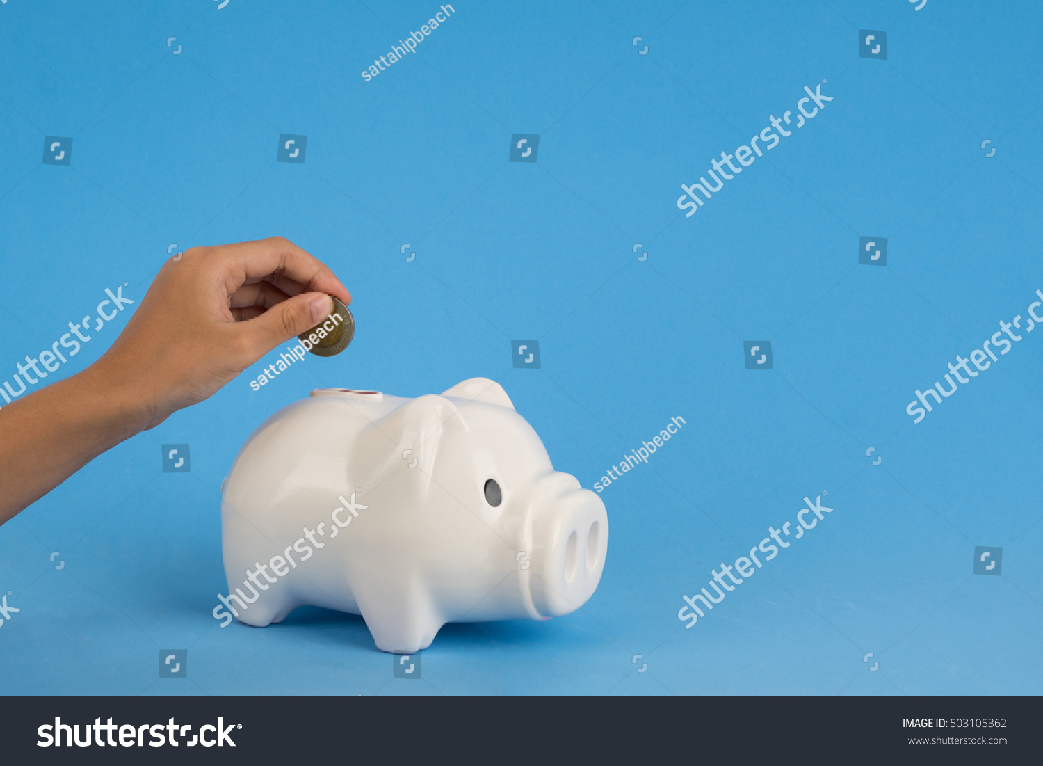 kids hand add coin to piggy bank save coin, time and money concept. copy space on right side. #503105362