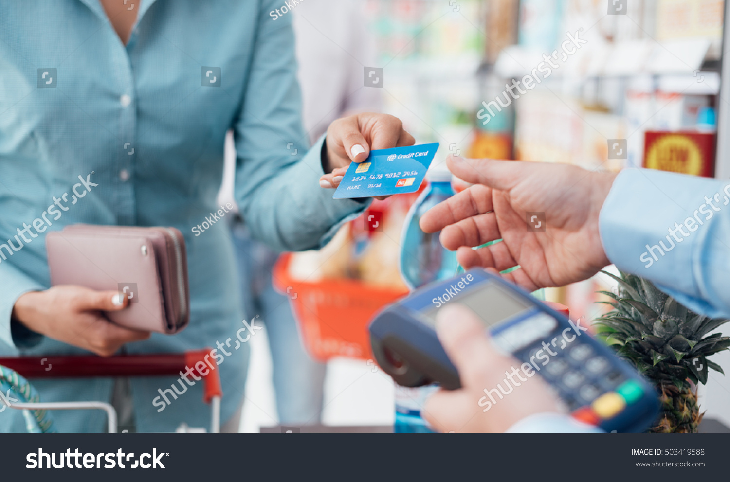 Woman at the supermarket checkout, she is paying using a credit card, shopping and retail concept #503419588