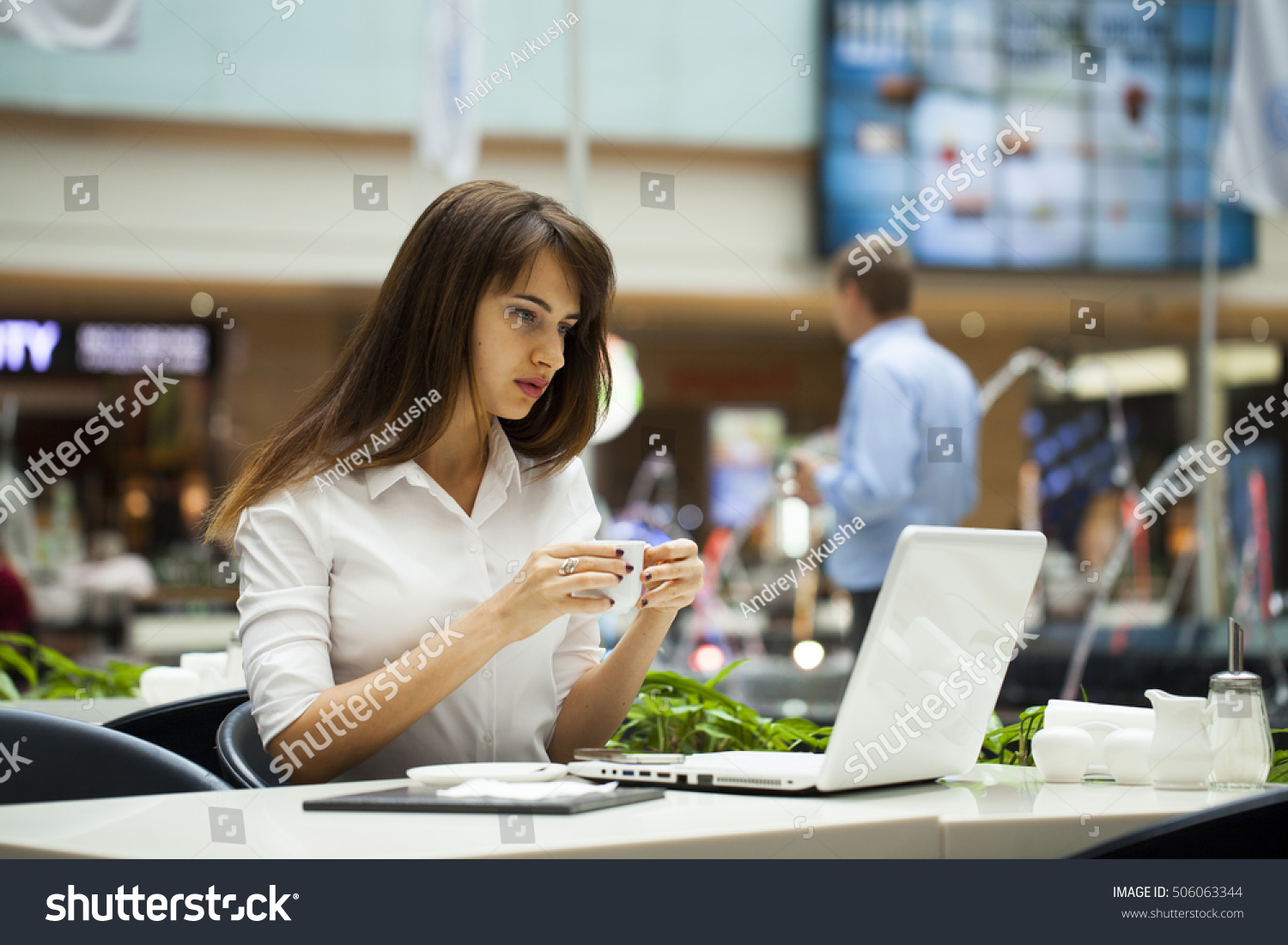 Young beautiful business woman drinking coffee while sitting in a restaurant #506063344