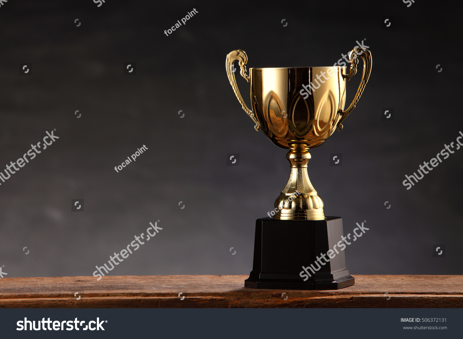 trophy on top of old wooden table in front of blackboard #506372131