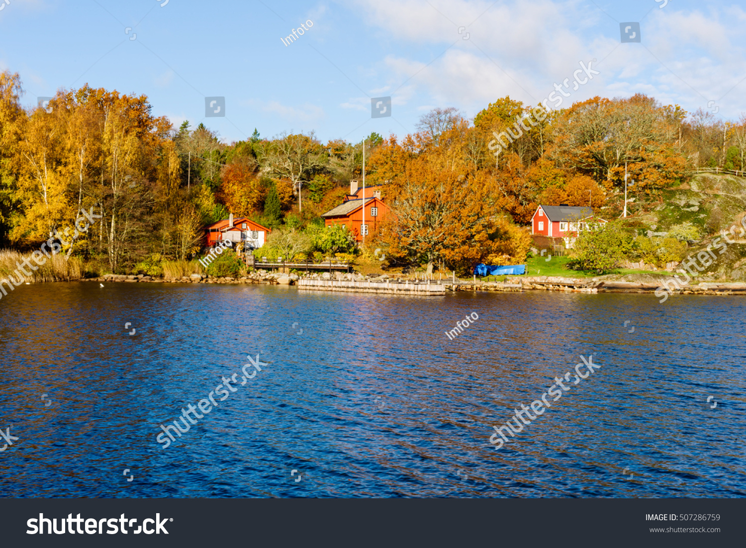 Jarnavik, Sweden - October 25, 2016: Environmental documentary of coastal lifestyle. Seaside homes with private piers in fall. Colorful woodland in background. #507286759