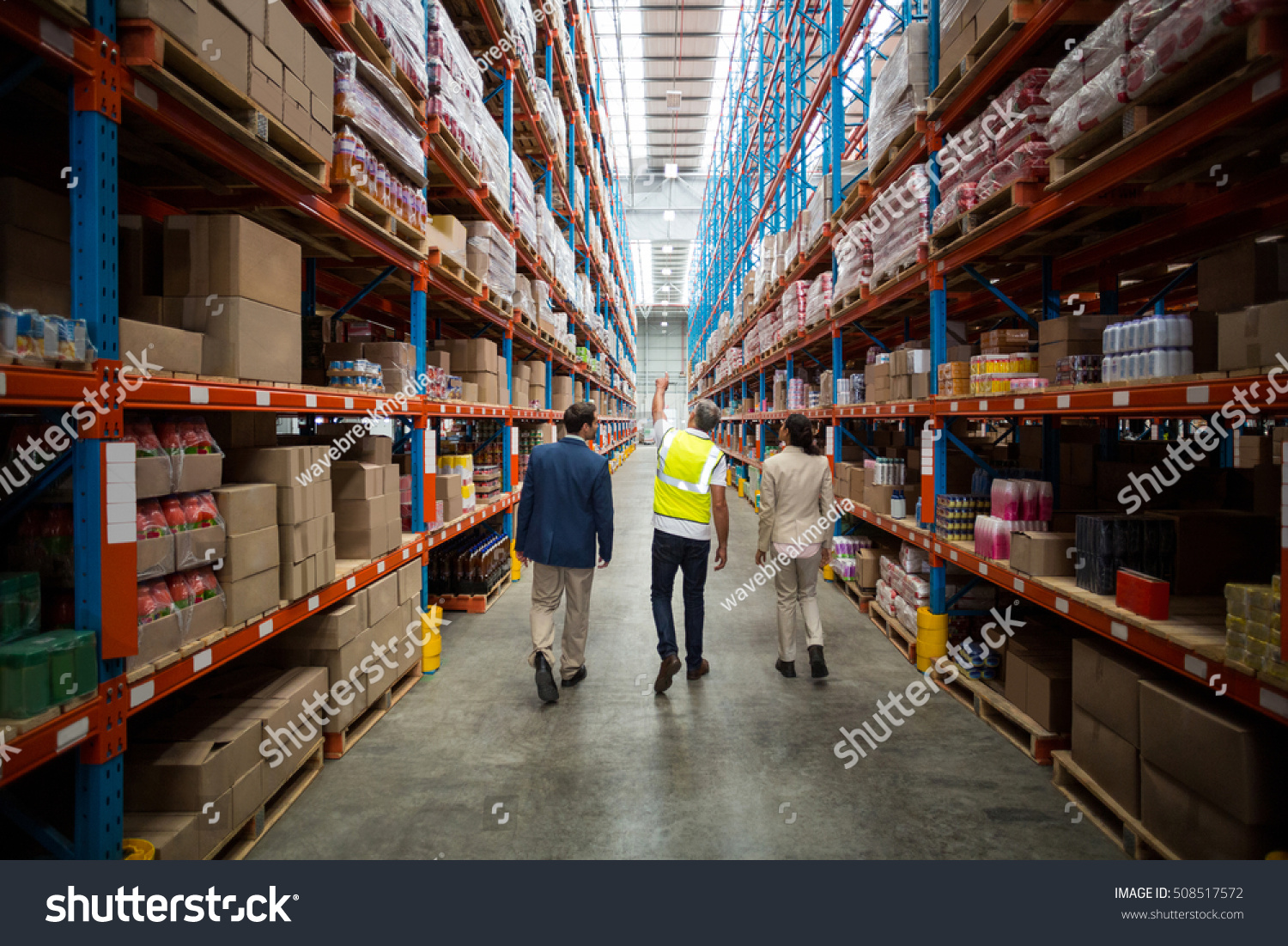 Rear view of warehouse team discussing while walking in warehouse #508517572