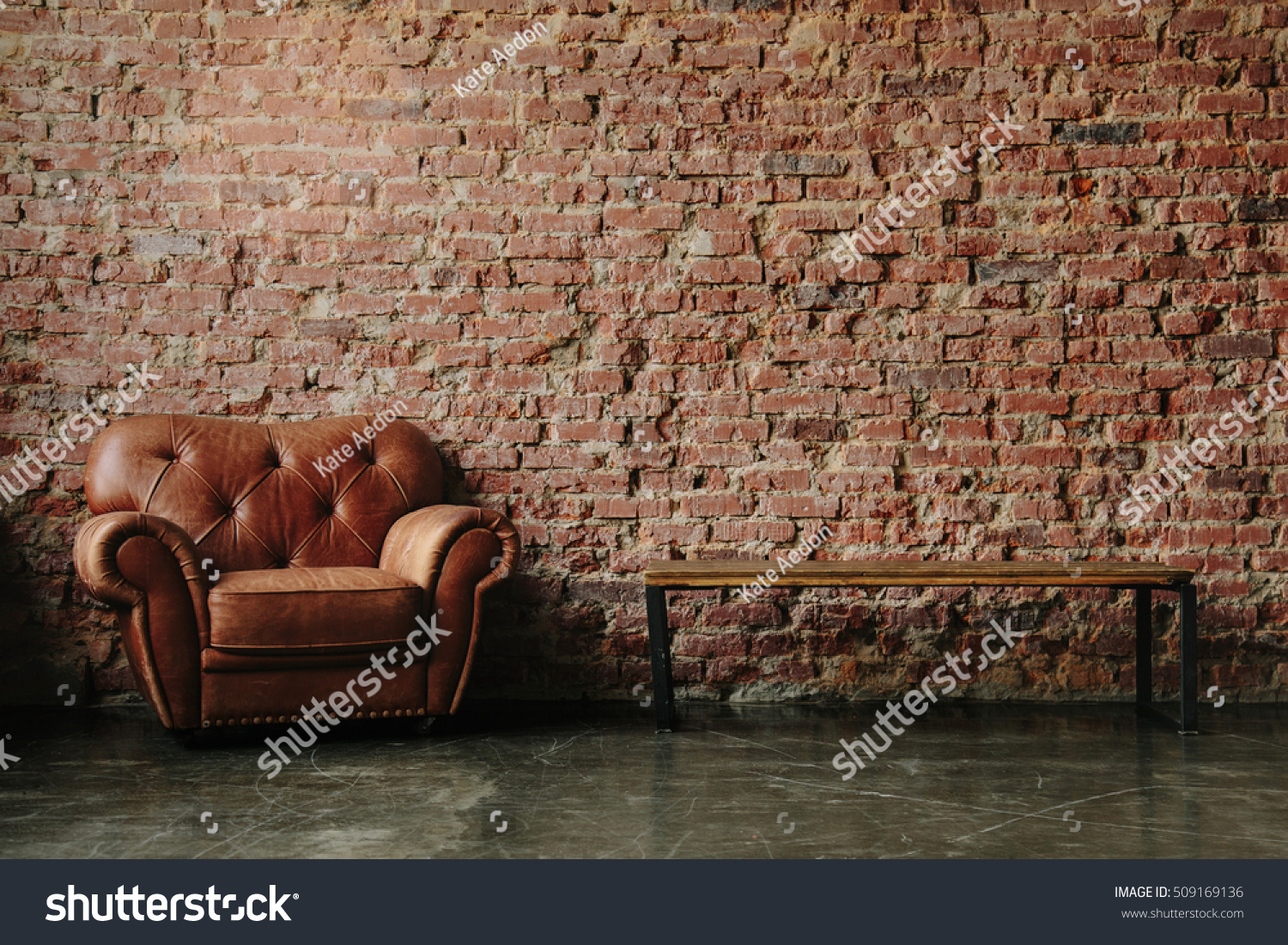 Loft interior mock up photo. Brown red brick wall with leather sofa and minimalist wooden table. Background photo with copy space for text. Horizontal #509169136
