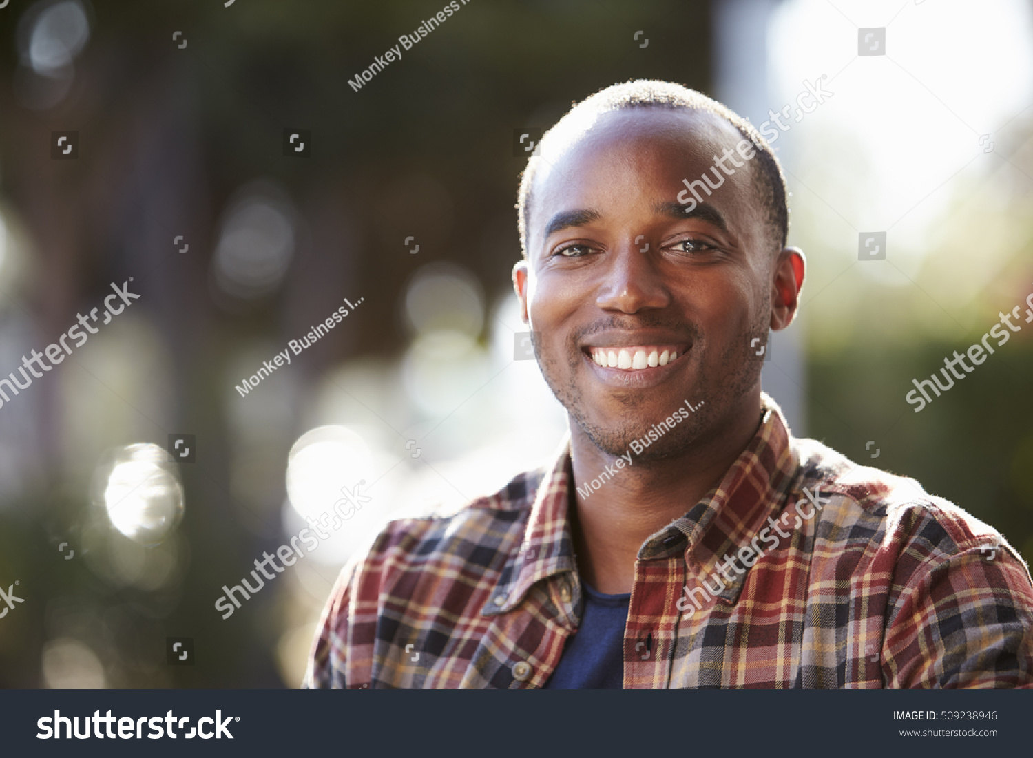 Young black man sitting outside, head and shoulders portrait #509238946