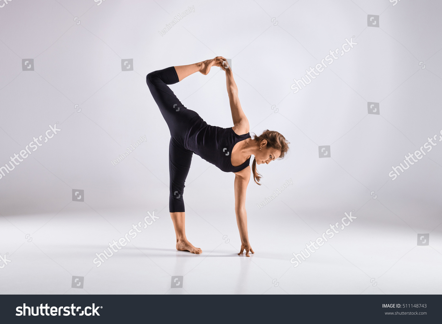 Sporty middle age woman doing yoga practice isolated on white background - concept of healthy life and natural balance between physical and mental evolution #511148743
