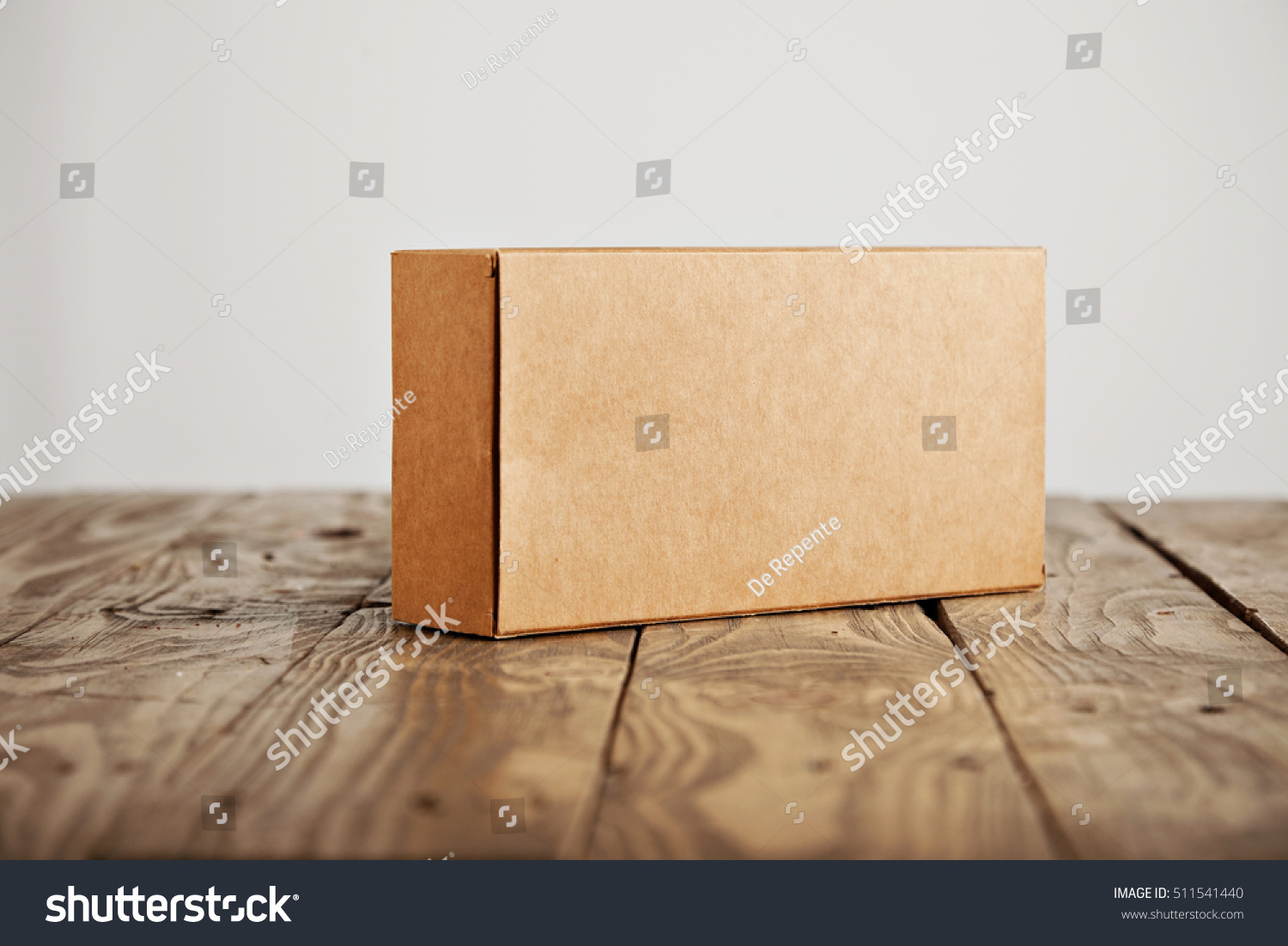 Craft unlabeled cardboard package box presented on stressed brushed wooden table, isolated on white background #511541440