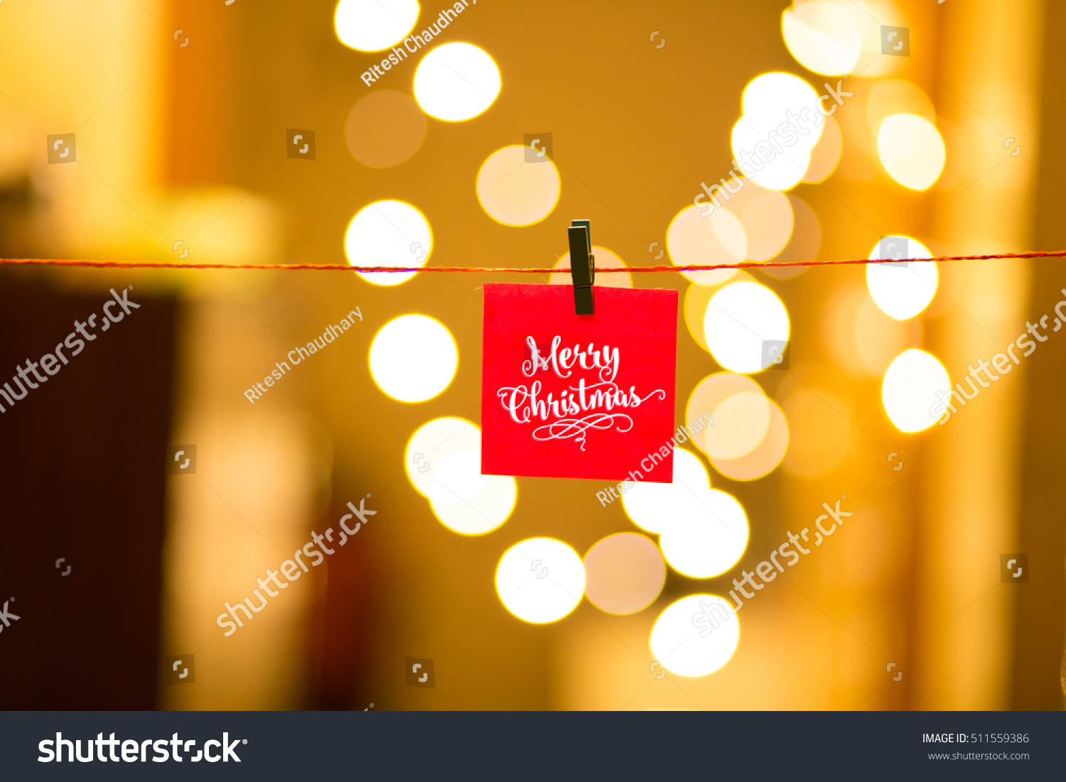Merry Christmas and Happy New Year post  it on a bokeh background hung with mini clips, festive defocused lights. #511559386