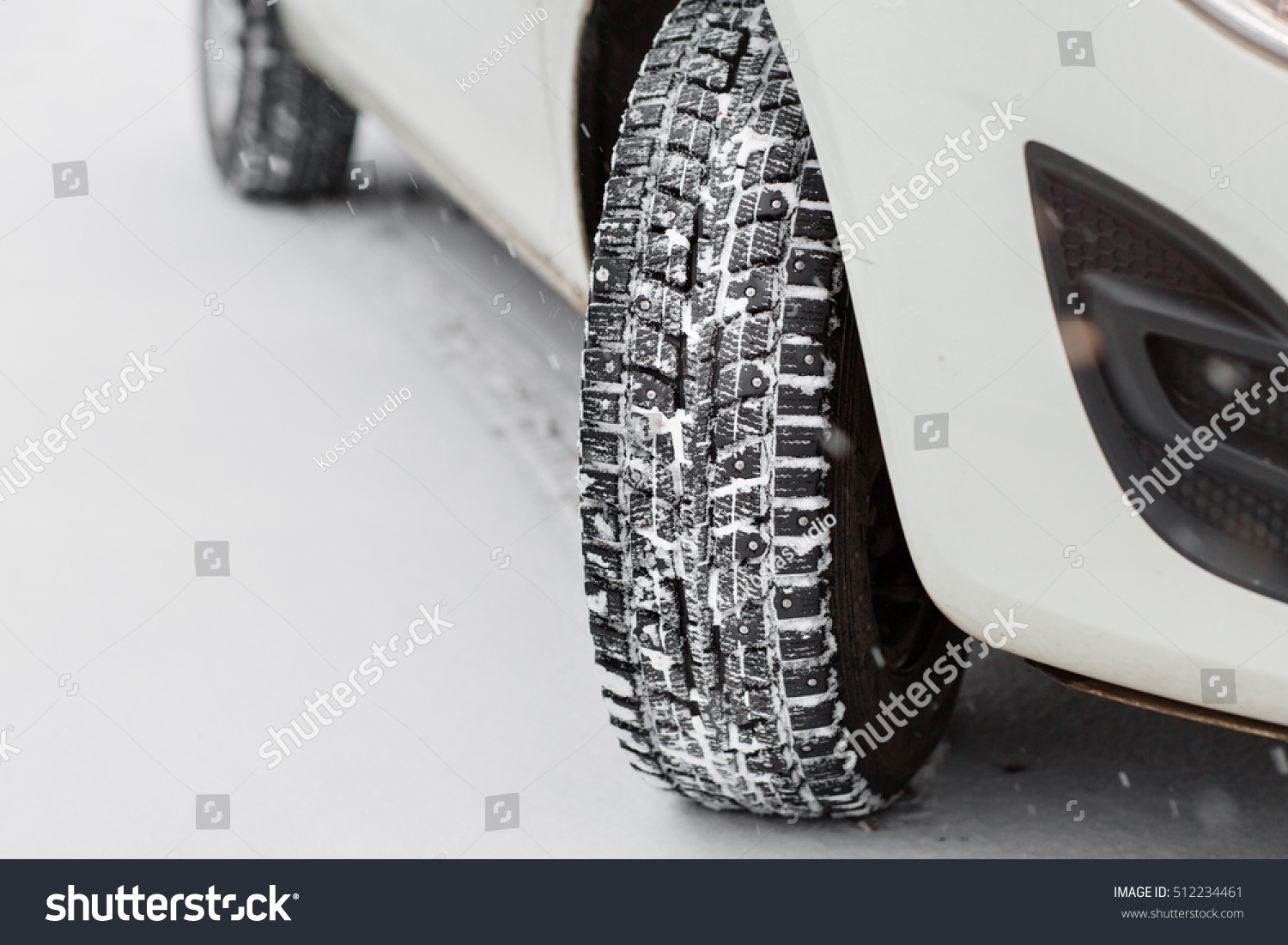 Closeup of car tires in winter. the first snow in late autumn #512234461