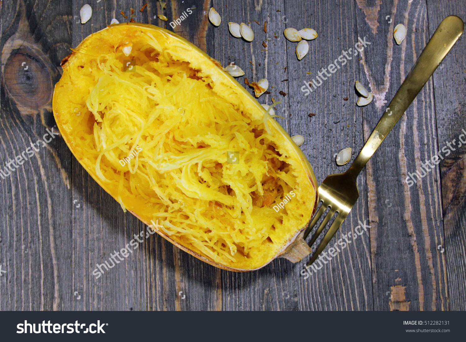 Overhead view of Spaghetti squash on a wooden background with squash seeds #512282131