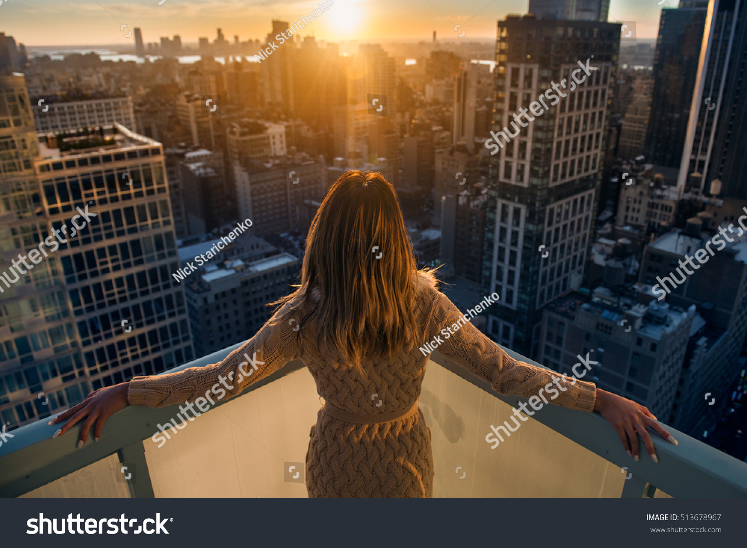 Rich woman enjoying the sunset standing on the balcony at luxury apartments in New York City. Luxury life concept. Successful businesswoman relaxing. #513678967