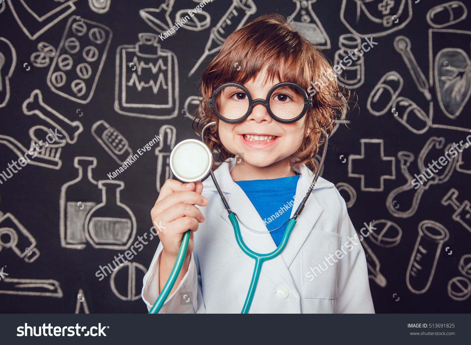 Happy little boy in doctor costume holding sthetoscope on dark background with pattern. The child has glasses #513691825