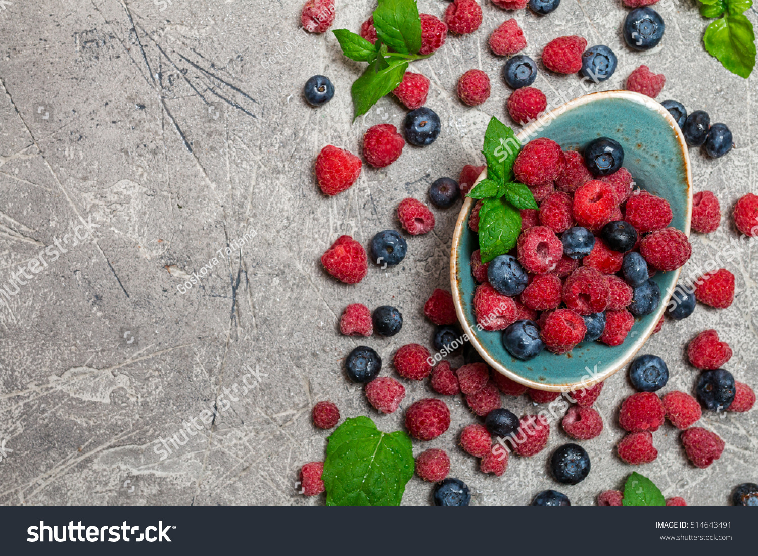 Fresh summer berries in vintage bowl over gray background,top view #514643491