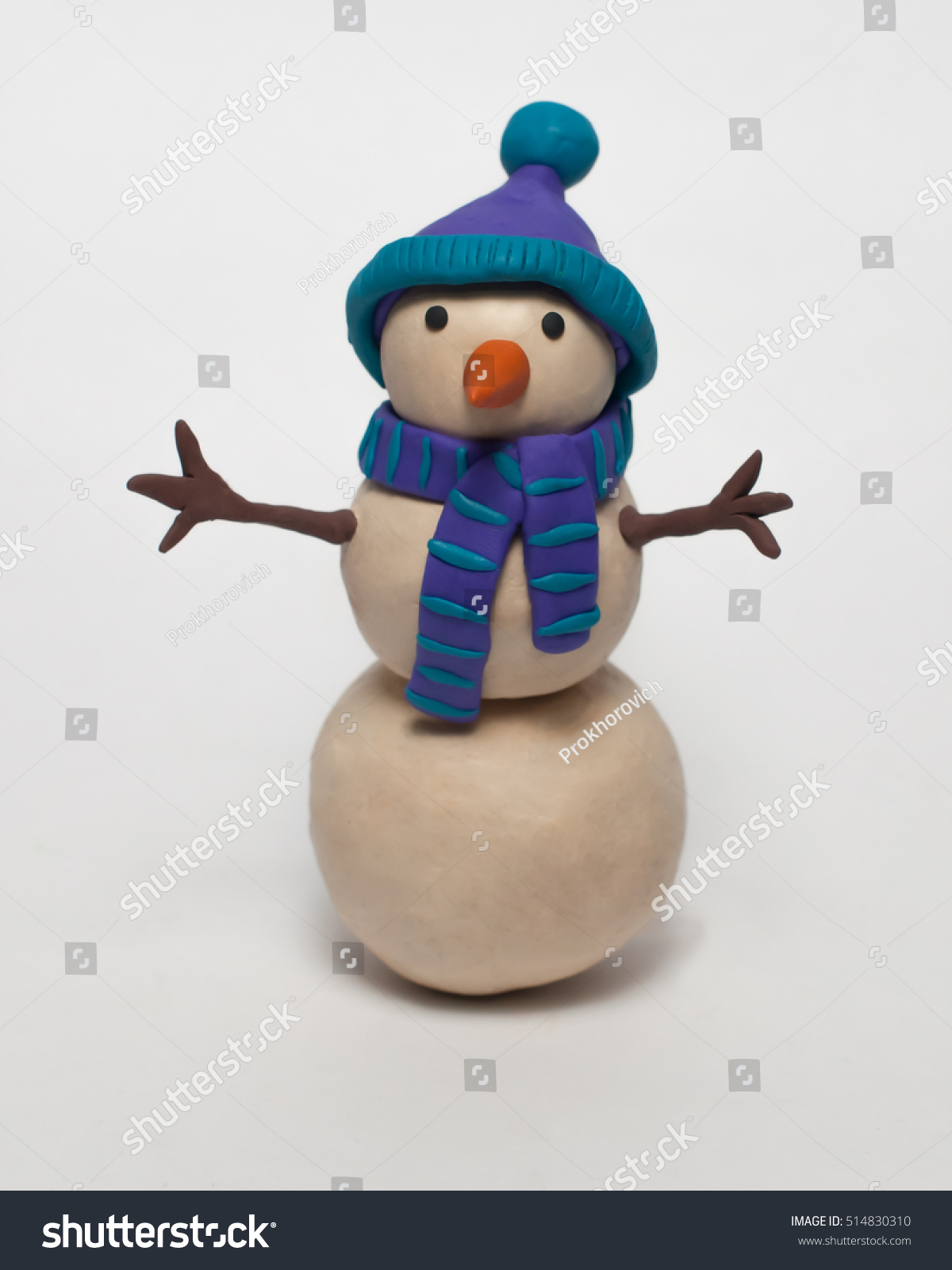 
Funny plasticine snowman in a blue hat and scarf isolated on white background #514830310