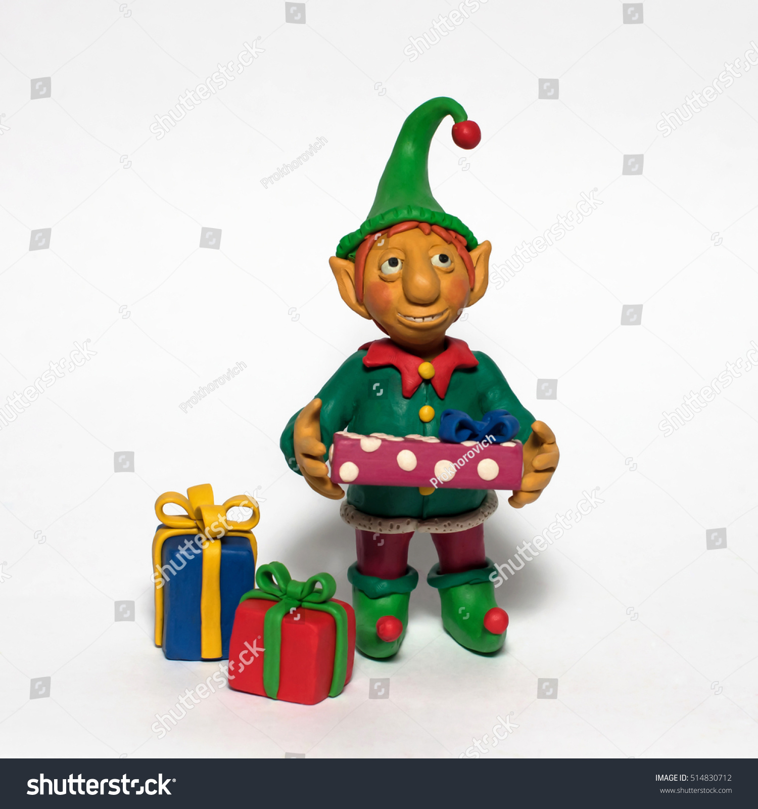 
Plasticine character. Funny Christmas elf holding a gift. Isolated on white background #514830712