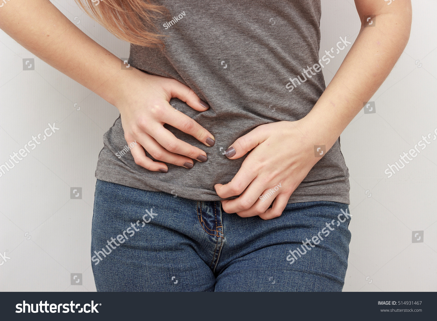 Young casual woman is having stomach ache. Woman making heart shape on her stomach. Gynecology, period, female healthcare, digestive system, Urinary Tract Infections #514931467