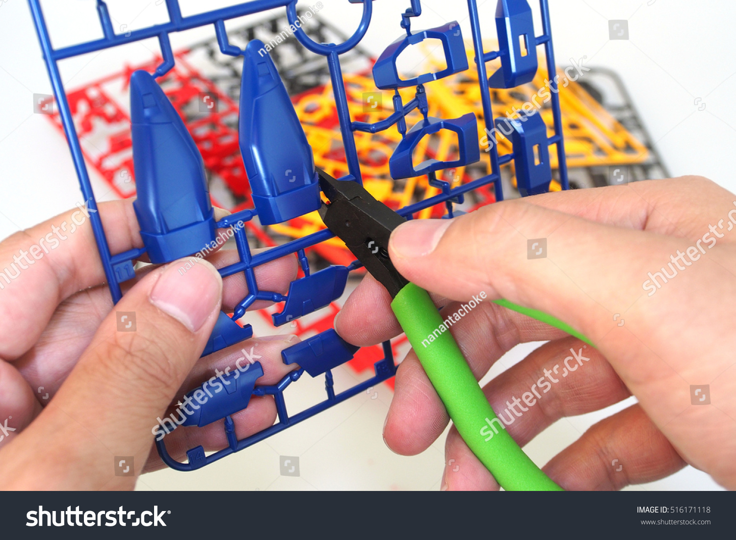 Man use nipper cutting a part of plastic model kit isolated on white background #516171118