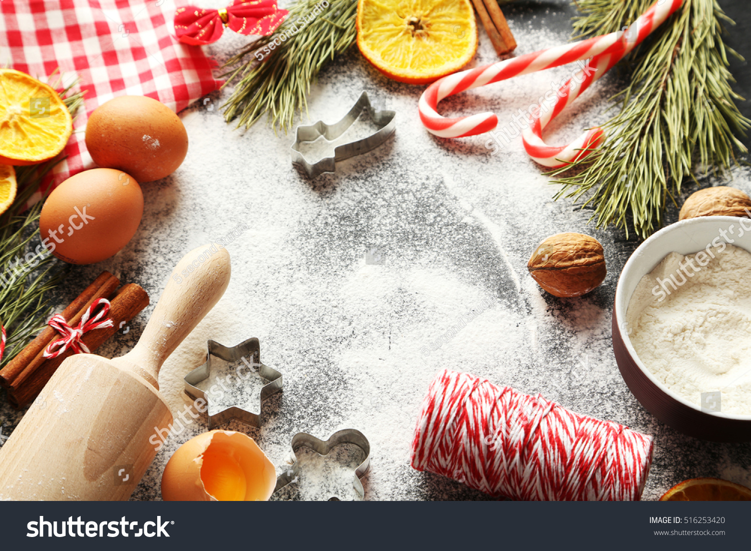 Christmas tree branch with dried oranges, cinnamon and flour on wooden table #516253420